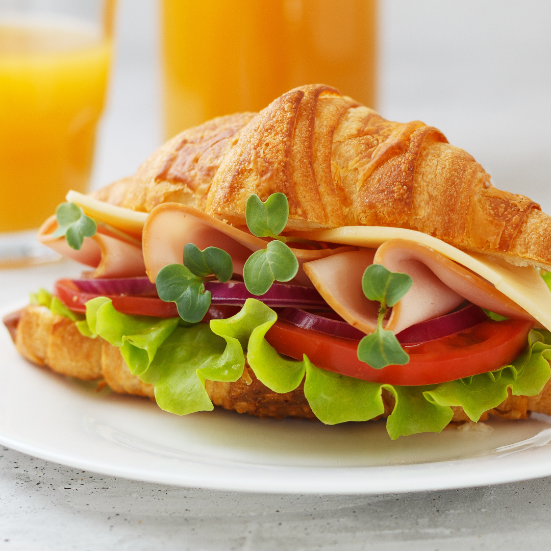 Croissant recheado com queijo, fiambre, tomate e salada.